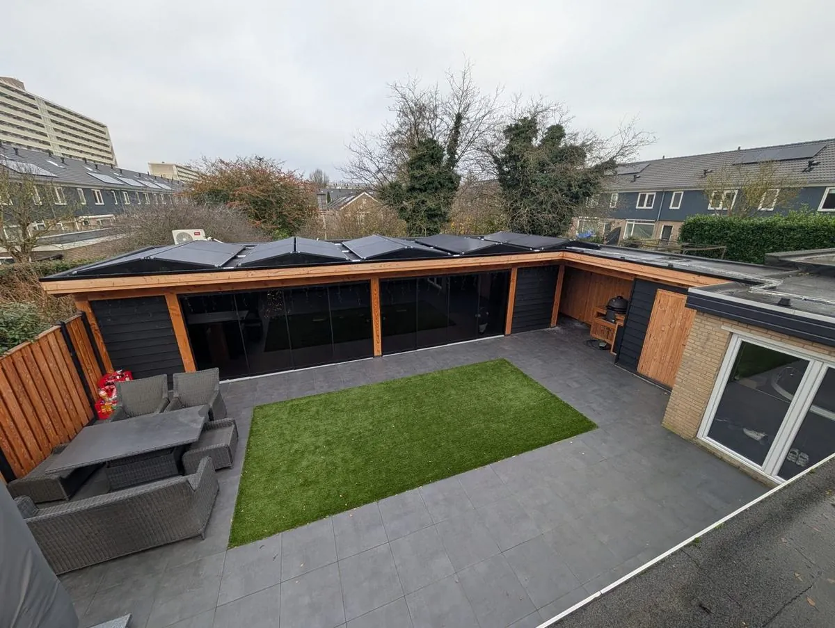 Tuin in Arnhem met zonnepanelen op het dak van de houten veranda
