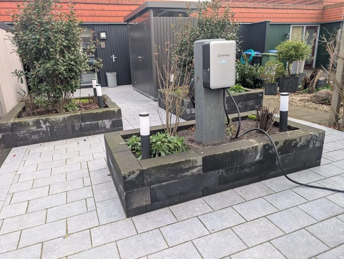 Enphase-laadpunt op een paal in een voortuin in Nijmegen